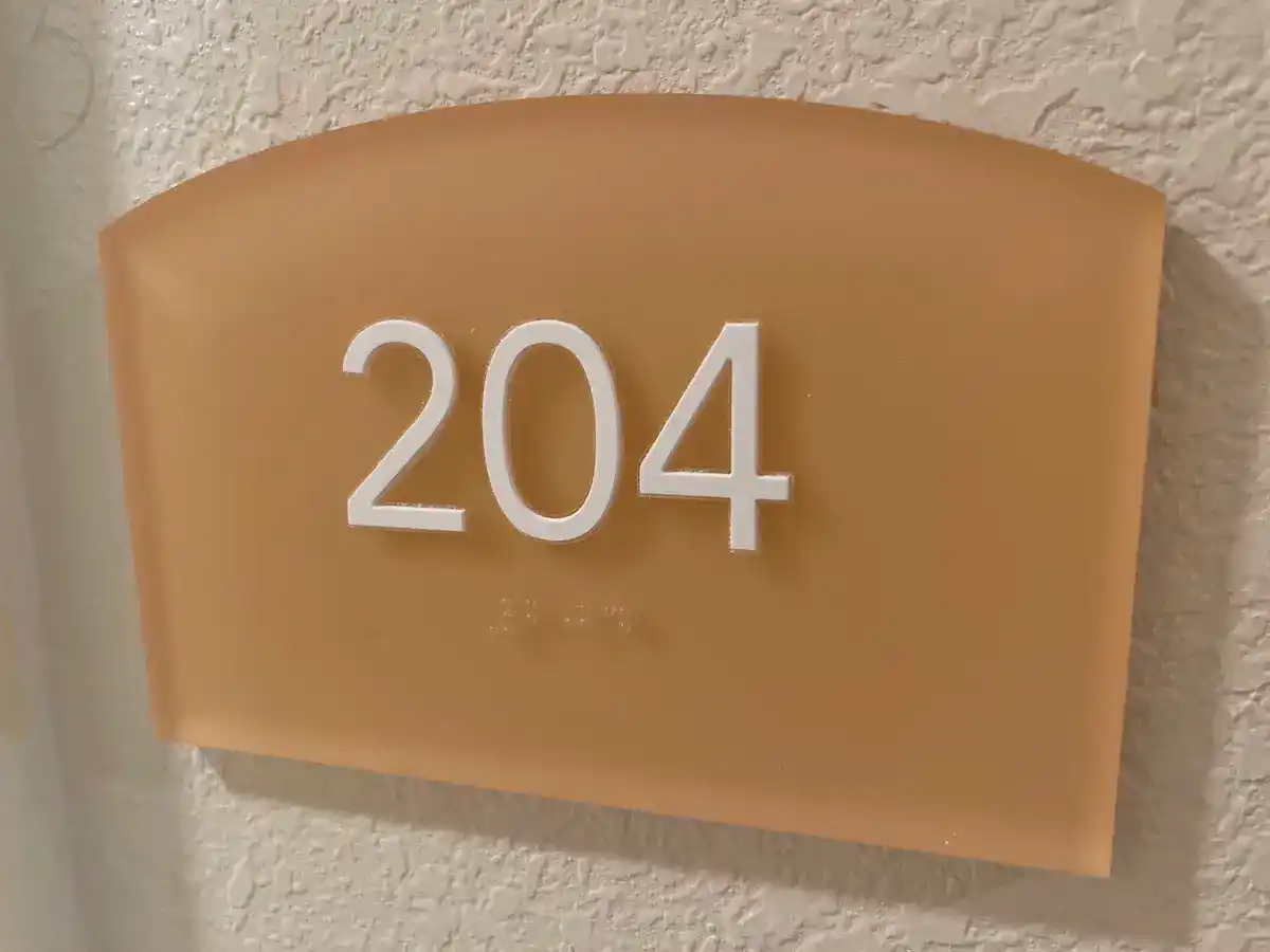 ADA compliant signage that says room number 204 for apartment complex