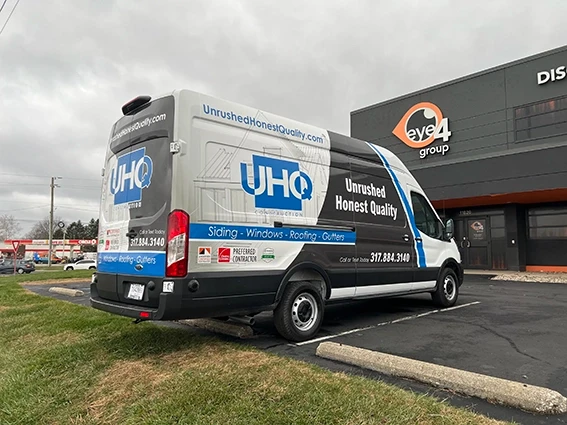 Full wrap on a Ford Transit van for UHQ Construction displaying the company logo, services including siding windows roofing and gutters, and phone number 317-884-3140, installed by Eye 4 Group in Indianapolis