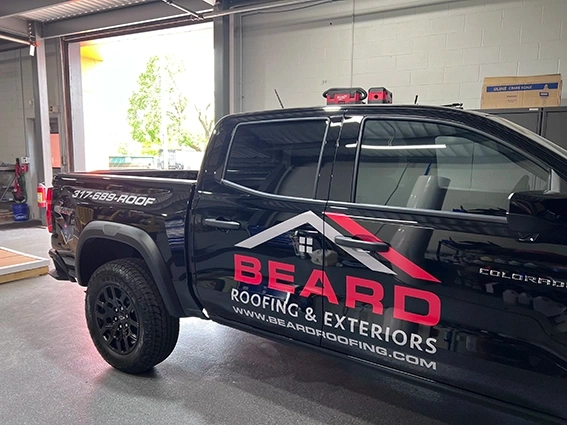 Full wrap on a black Chevrolet Colorado for Beard Roofing and Exteriors featuring bold red and white branding with the company logo, website beardroofing.com, and phone number 317-699-ROOF, installed by Eye 4 Group in Indianapolis