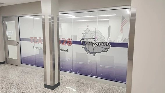 Interior view of perforated window vinyl installed on school office windows featuring a purple gradient design with the Bulldogs mascot logo and Team 28 Brownsburg School branding, installed by Eye 4 Group in Indianapolis