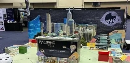 Eye 4 Group custom trade show display booth featuring an Indianapolis skyline backdrop, branded signage, and multi-tenant property signage game display at an Indianapolis convention