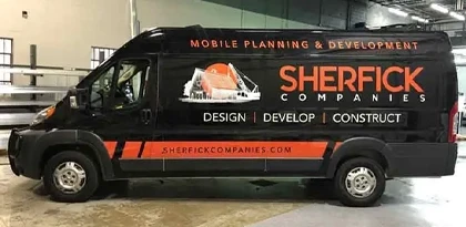 Sherfick Companies full cargo van wrap in black and orange with Mobile Planning and Development branding, Design Develop Construct tagline, and company website, installed by Eye 4 Group Indianapolis